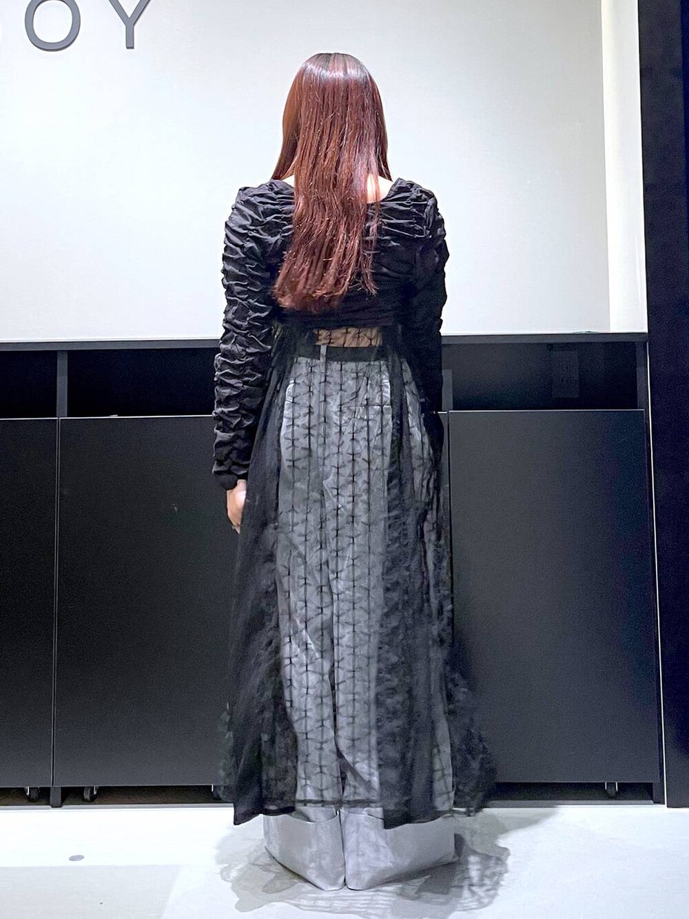 ブラック系のパンプス、ブラック系のショルダーバッグ、ブラック系のワンピースを着用したレディースの夏コーディネートの6枚目の写真