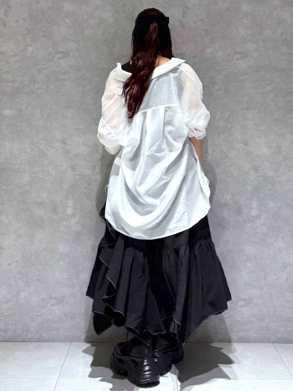 ブラック系のブーツ、ブラック系のスカート、ホワイト系のシャツ/ブラウスを着用したレディースの春コーディネートの4枚目の写真