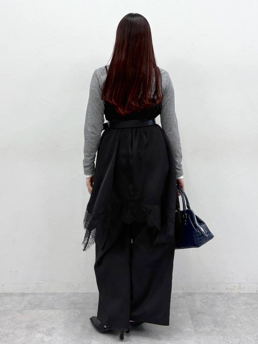 ブルー系のハンドバッグ、ブラック系のスラックス、ブラック系のサンダルを着用したレディースの春コーディネートの6枚目の写真