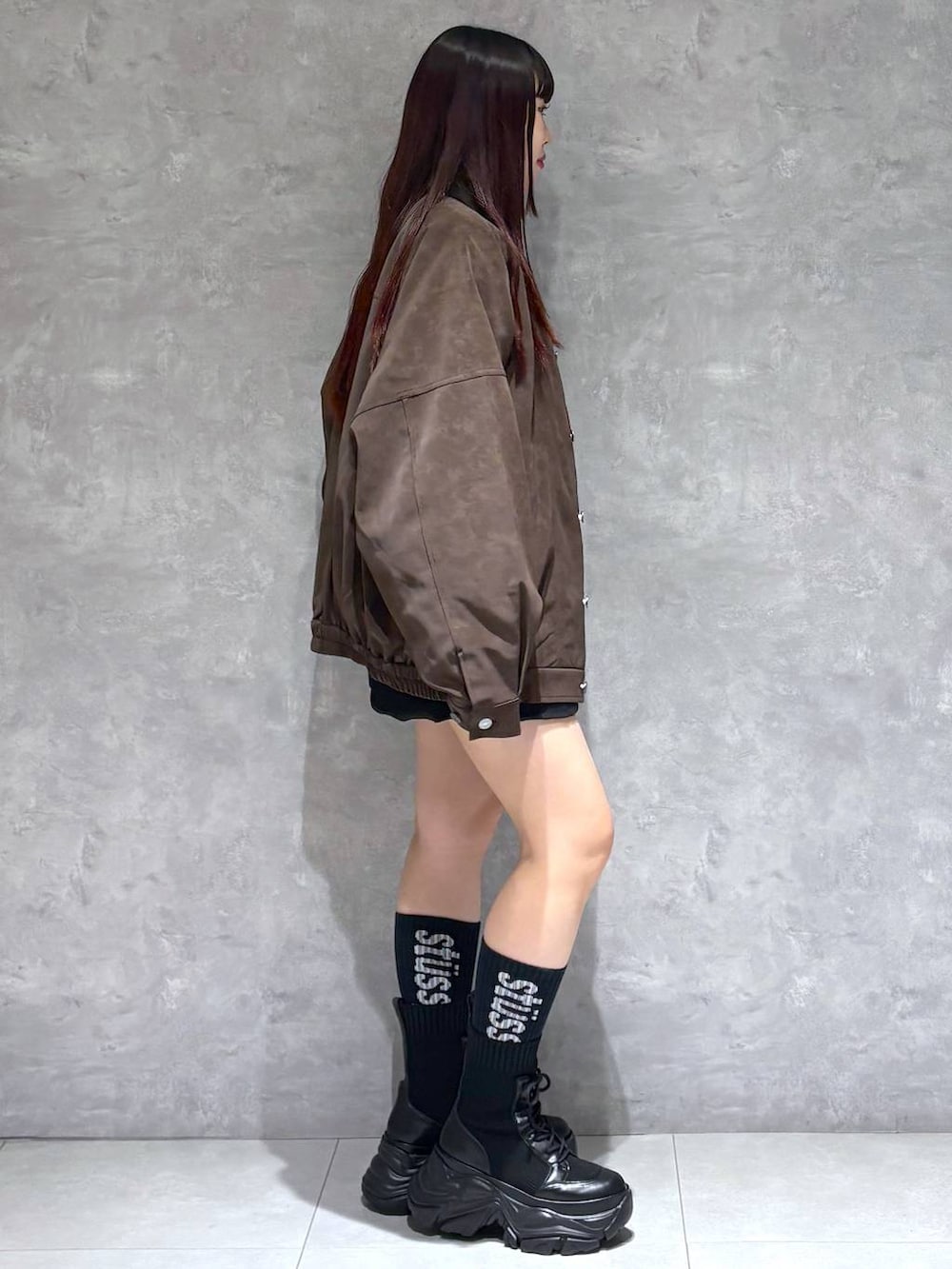 ブラック系のブーツ、ブラウン系のブルゾン、ブラック系のニット/セーターを着用したレディースの秋コーディネートの6枚目の写真