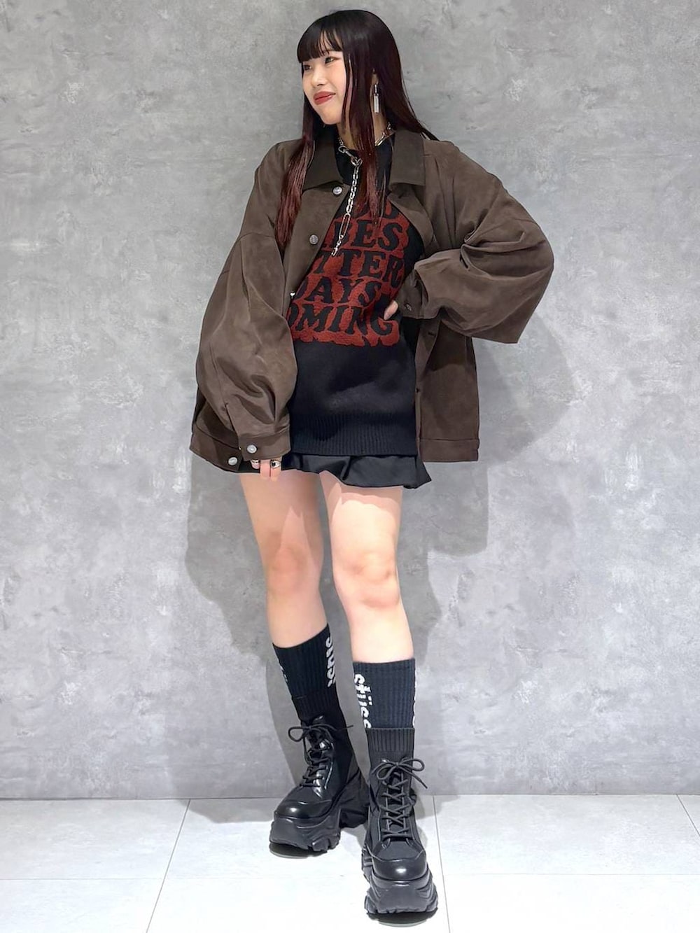 ブラック系のブーツ、ブラウン系のブルゾン、ブラック系のニット/セーターを着用したレディースの秋コーディネートの3枚目の写真