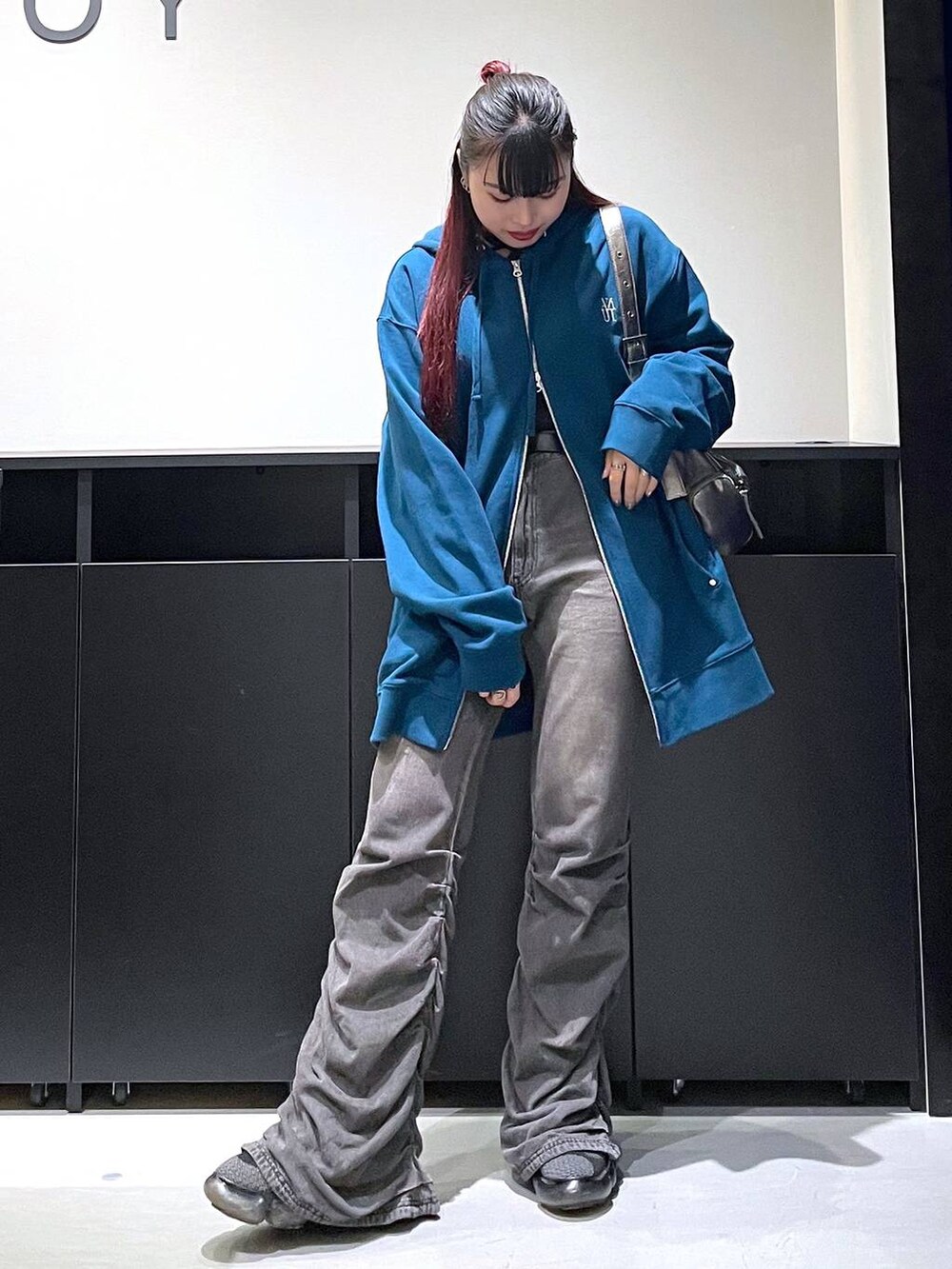 ブラック系のデニムパンツ、その他のショルダーバッグ、ブルー系のパーカーを着用したレディースの秋コーディネートの2枚目の写真