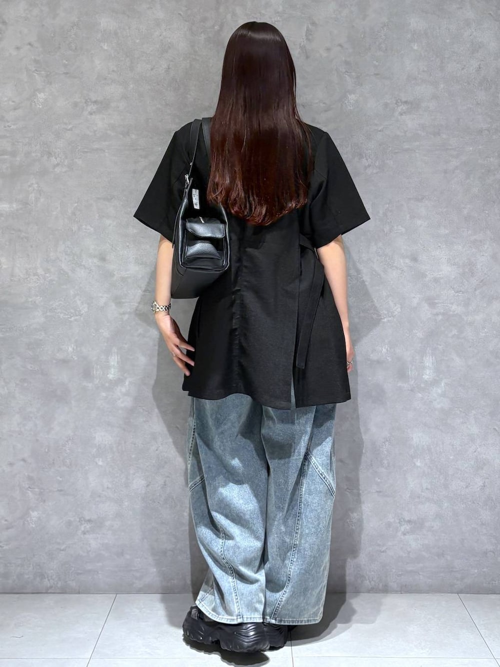ブルー系のデニムパンツ、グレー系のサンダル、ブラック系のテーラードジャケットを着用したレディースの春コーディネートの5枚目の写真