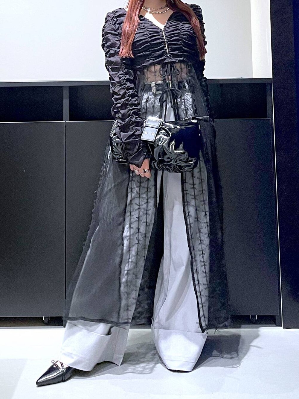 ブラック系のパンプス、ブラック系のショルダーバッグ、ブラック系のワンピースを着用したレディースの夏コーディネートの3枚目の写真