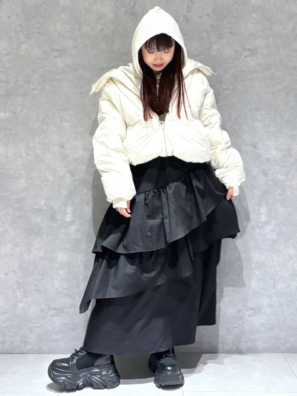 ブラック系のブーツ、ホワイト系のブルゾン、ベージュ系のパーカーを着用したレディースの冬コーディネートの9枚目の写真