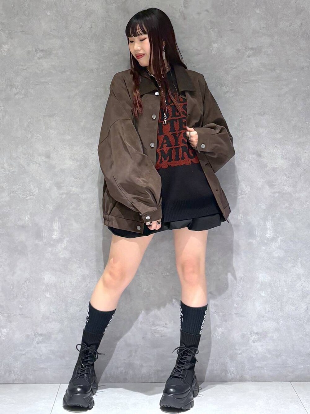 ブラック系のブーツ、ブラウン系のブルゾン、ブラック系のニット/セーターを着用したレディースの秋コーディネートの2枚目の写真