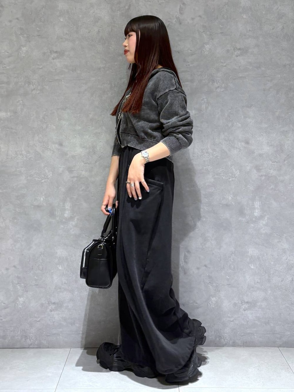 ブラック系のスウェットパンツ、ブラック系のショルダーバッグ、グレー系のパーカーを着用したレディースの冬コーディネートの4枚目の写真