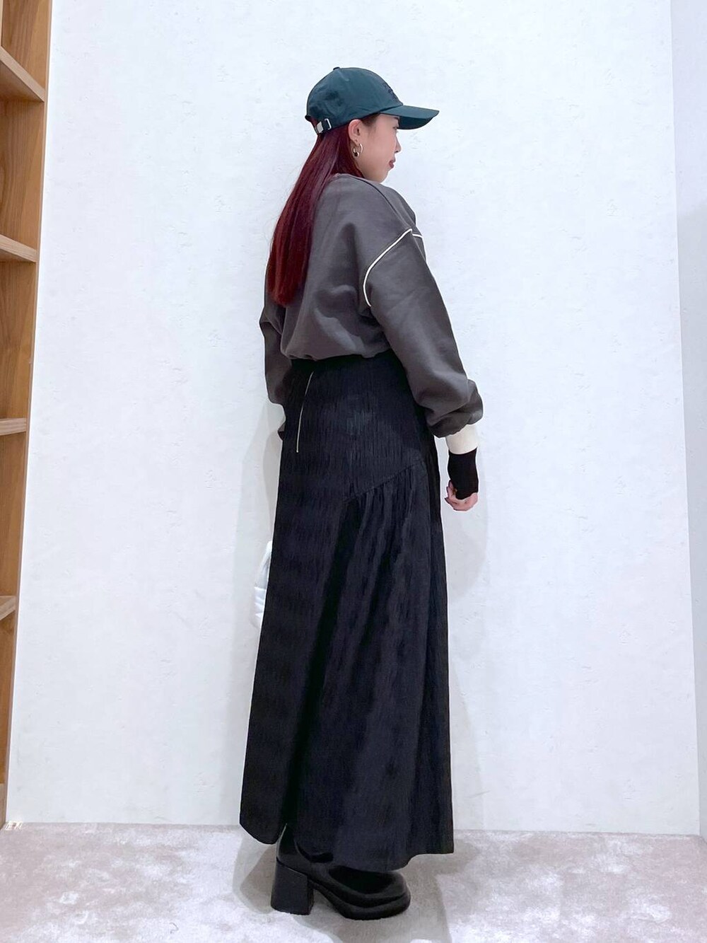 グレー系のスウェット、ブラック系のTシャツ/カットソー、ブラック系のブーツを着用したレディースの冬コーディネートの9枚目の写真