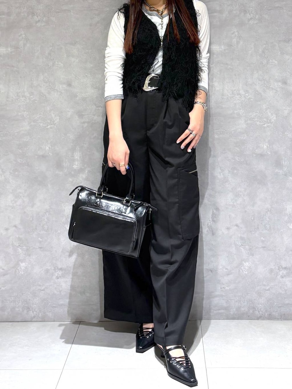 ブラック系のショルダーバッグ、ブラック系のスラックス、ブラック系のサンダルを着用したレディースの春コーディネートの7枚目の写真