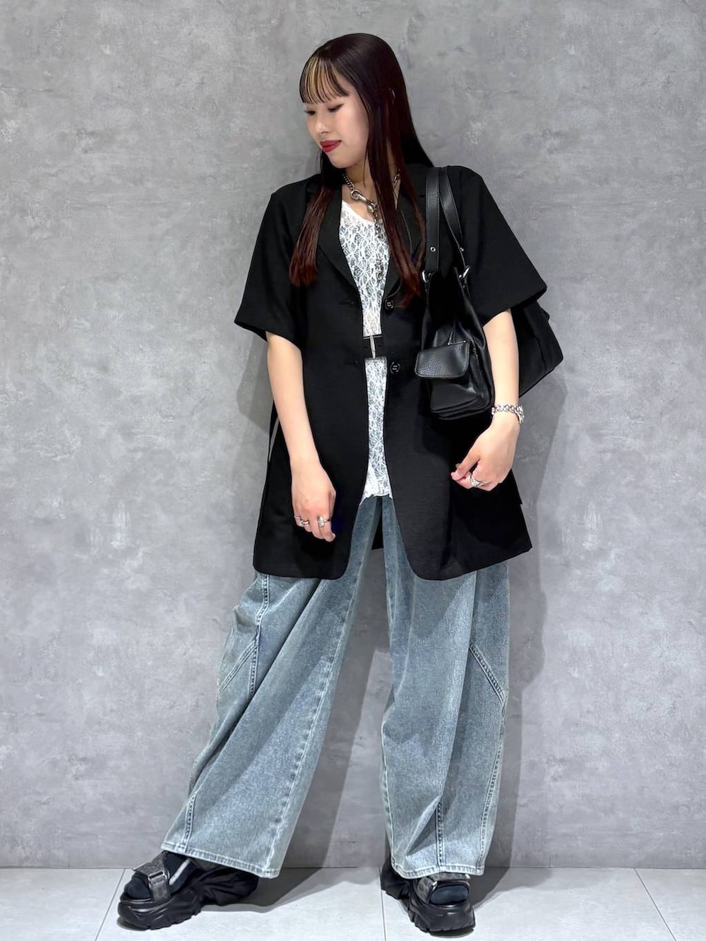 ブルー系のデニムパンツ、グレー系のサンダル、ブラック系のテーラードジャケットを着用したレディースの春コーディネートの8枚目の写真