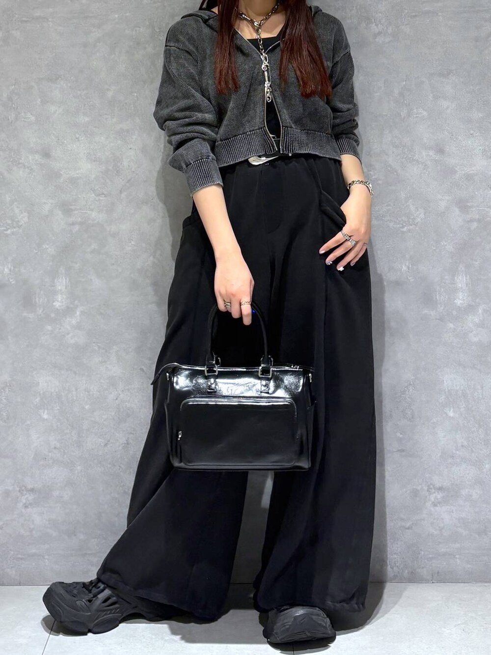 ブラック系のスウェットパンツ、ブラック系のショルダーバッグ、グレー系のパーカーを着用したレディースの冬コーディネートの7枚目の写真