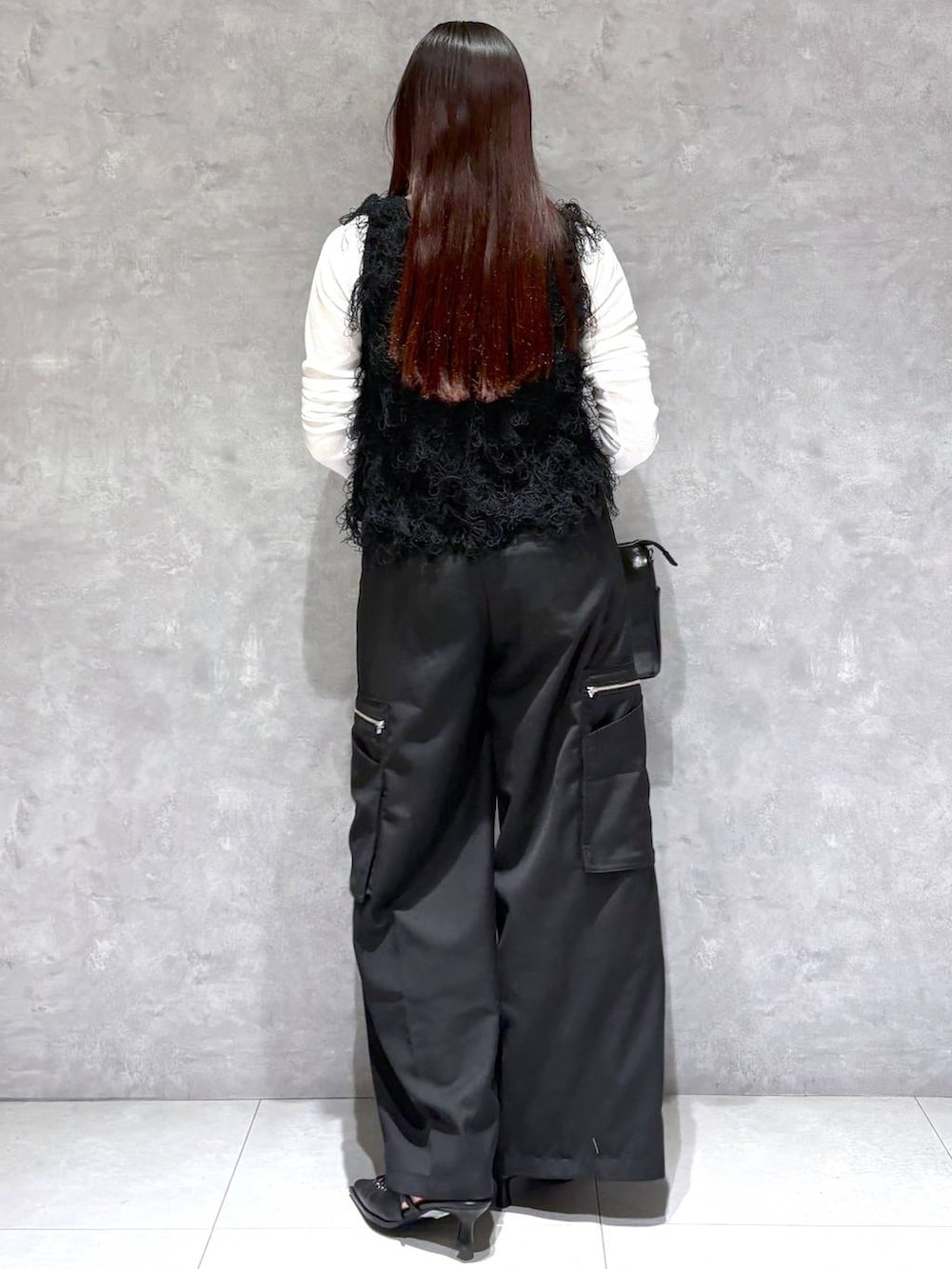 ブラック系のショルダーバッグ、ブラック系のスラックス、ブラック系のサンダルを着用したレディースの春コーディネートの4枚目の写真