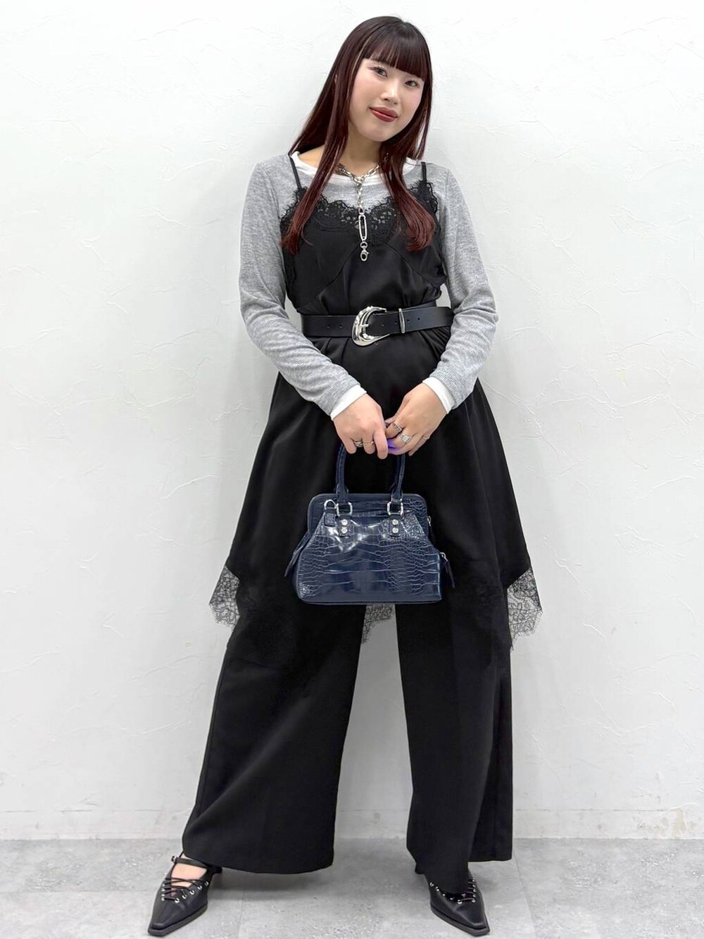 ブルー系のハンドバッグ、ブラック系のスラックス、ブラック系のサンダルを着用したレディースの春コーディネートの9枚目の写真