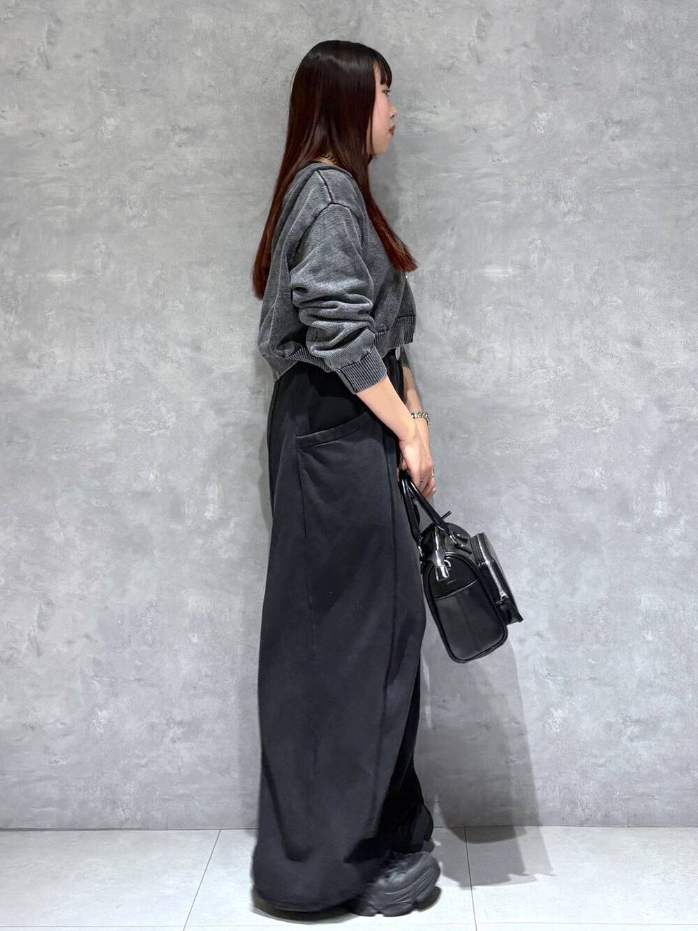 ブラック系のスウェットパンツ、ブラック系のショルダーバッグ、グレー系のパーカーを着用したレディースの冬コーディネートの6枚目の写真