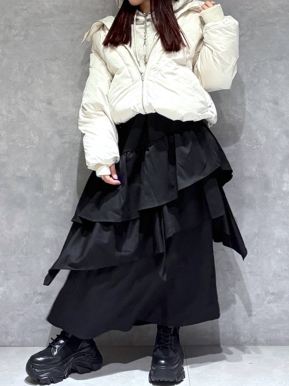 ブラック系のブーツ、ホワイト系のブルゾン、ベージュ系のパーカーを着用したレディースの冬コーディネートの3枚目の写真