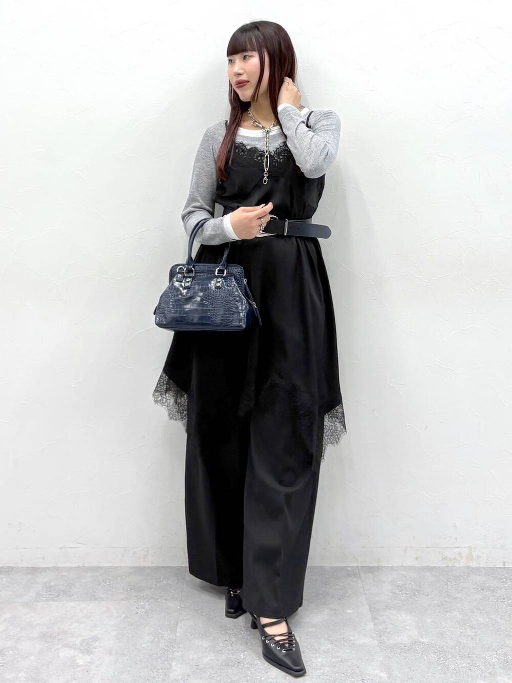 ブルー系のハンドバッグ、ブラック系のスラックス、ブラック系のサンダルを着用したレディースの春コーディネートの4枚目の写真