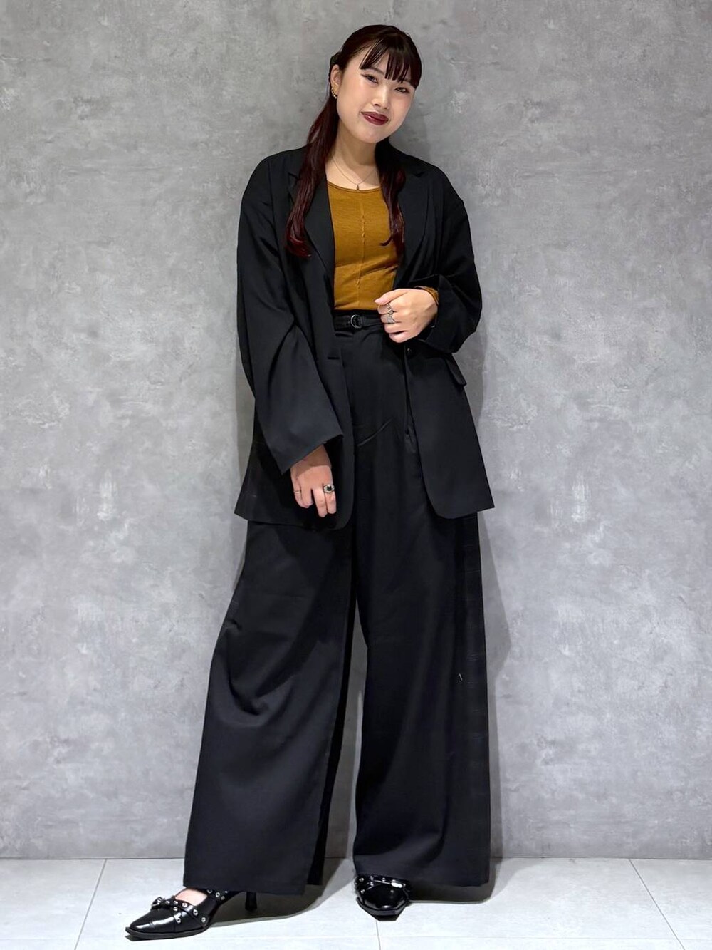 ブラック系のパンプス、ブラック系のテーラードジャケット、グレー系のスラックスを着用したレディースの秋コーディネートの2枚目の写真