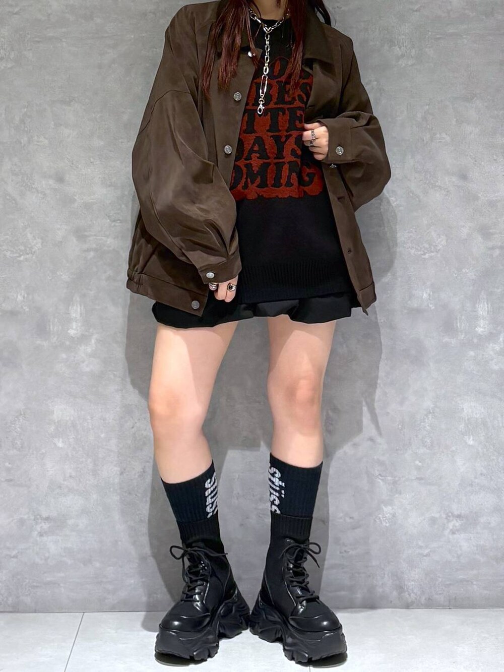 ブラック系のブーツ、ブラウン系のブルゾン、ブラック系のニット/セーターを着用したレディースの秋コーディネートの9枚目の写真