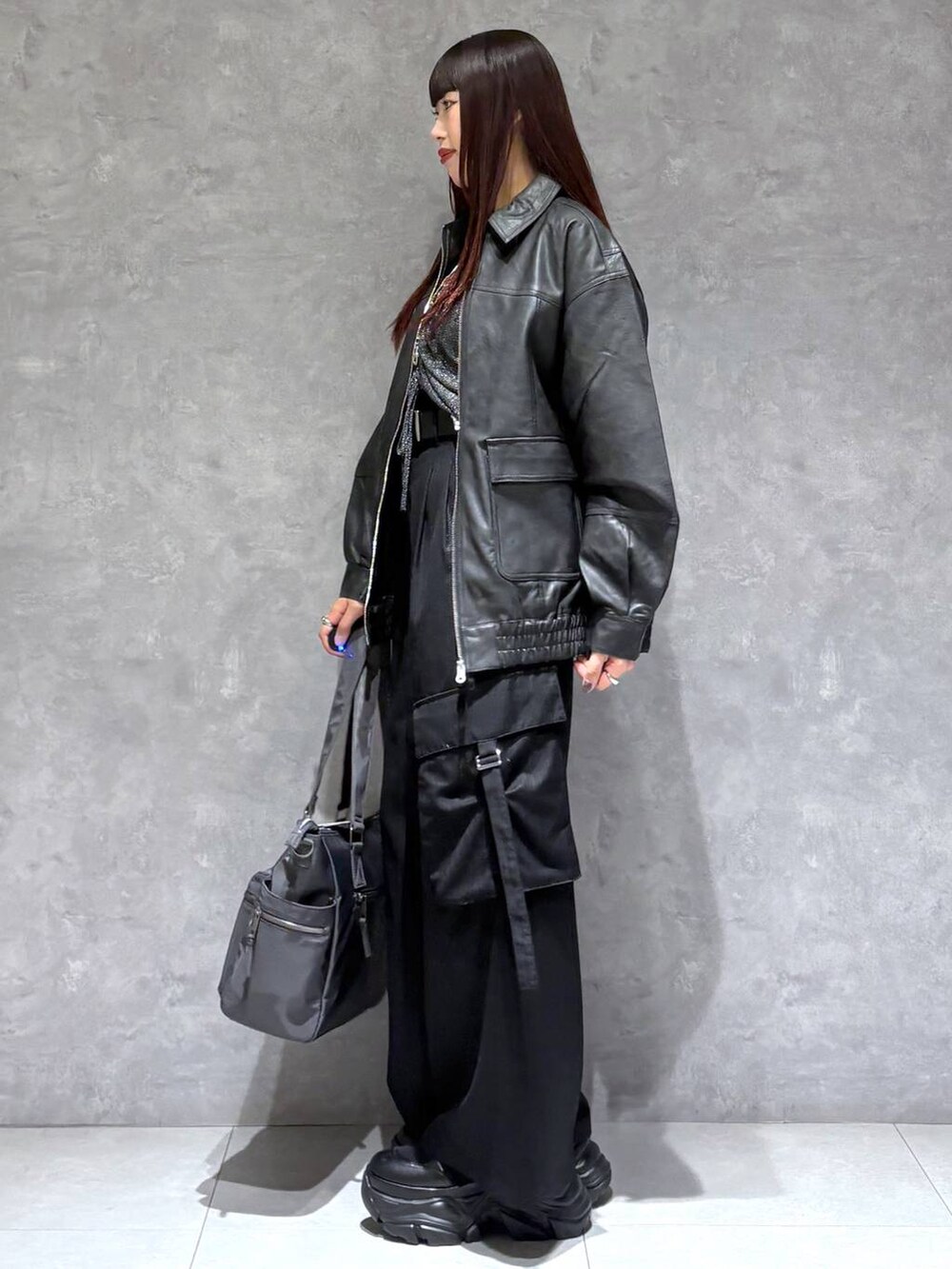 ブラック系のブーツ、グレー系のボストンバッグ、ブラック系のブルゾンを着用したレディースの秋コーディネートの4枚目の写真