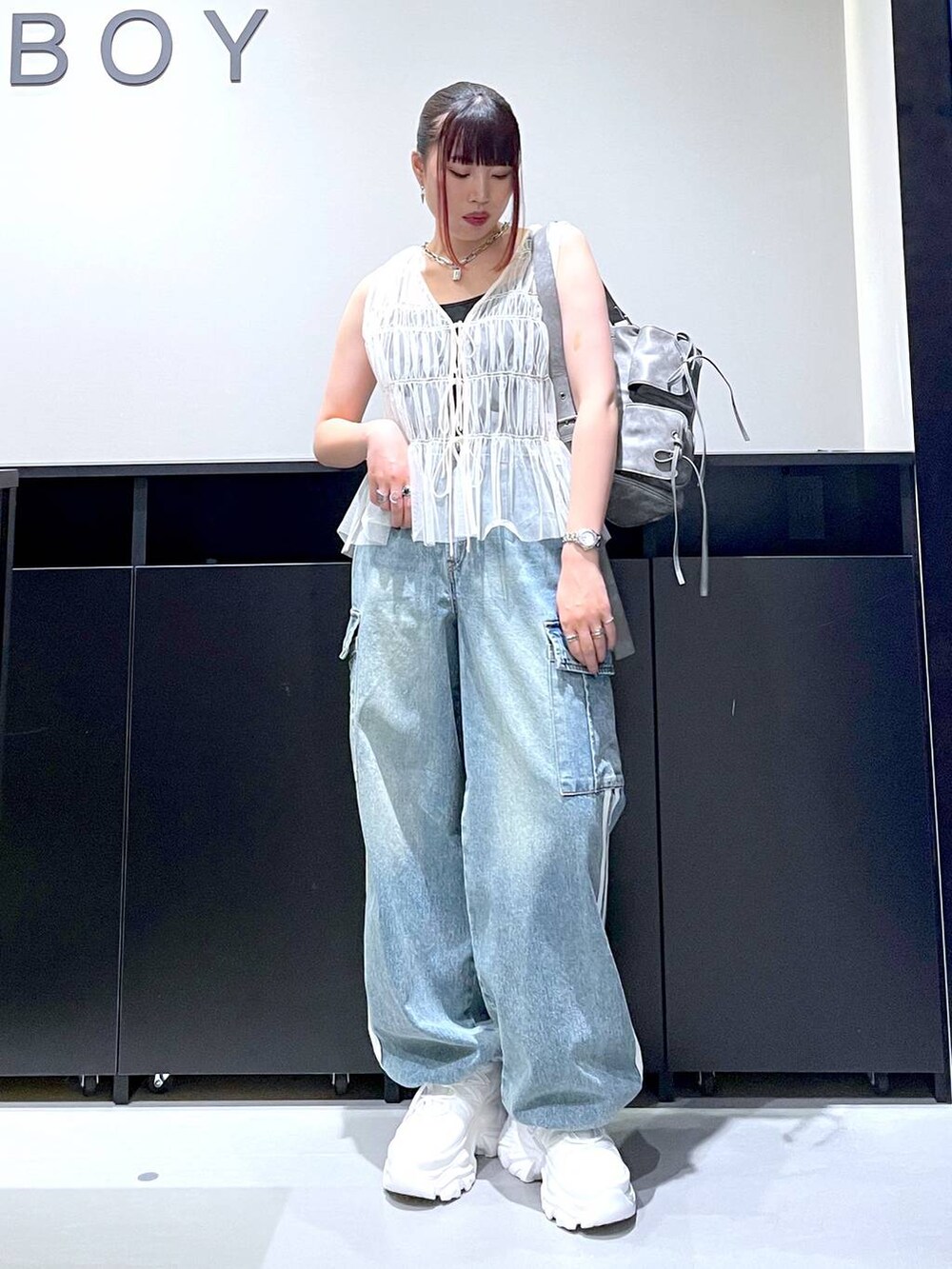 ホワイト系のスニーカー、ブルー系のデニムパンツ、グレー系のショルダーバッグを着用したレディースの夏コーディネートの8枚目の写真