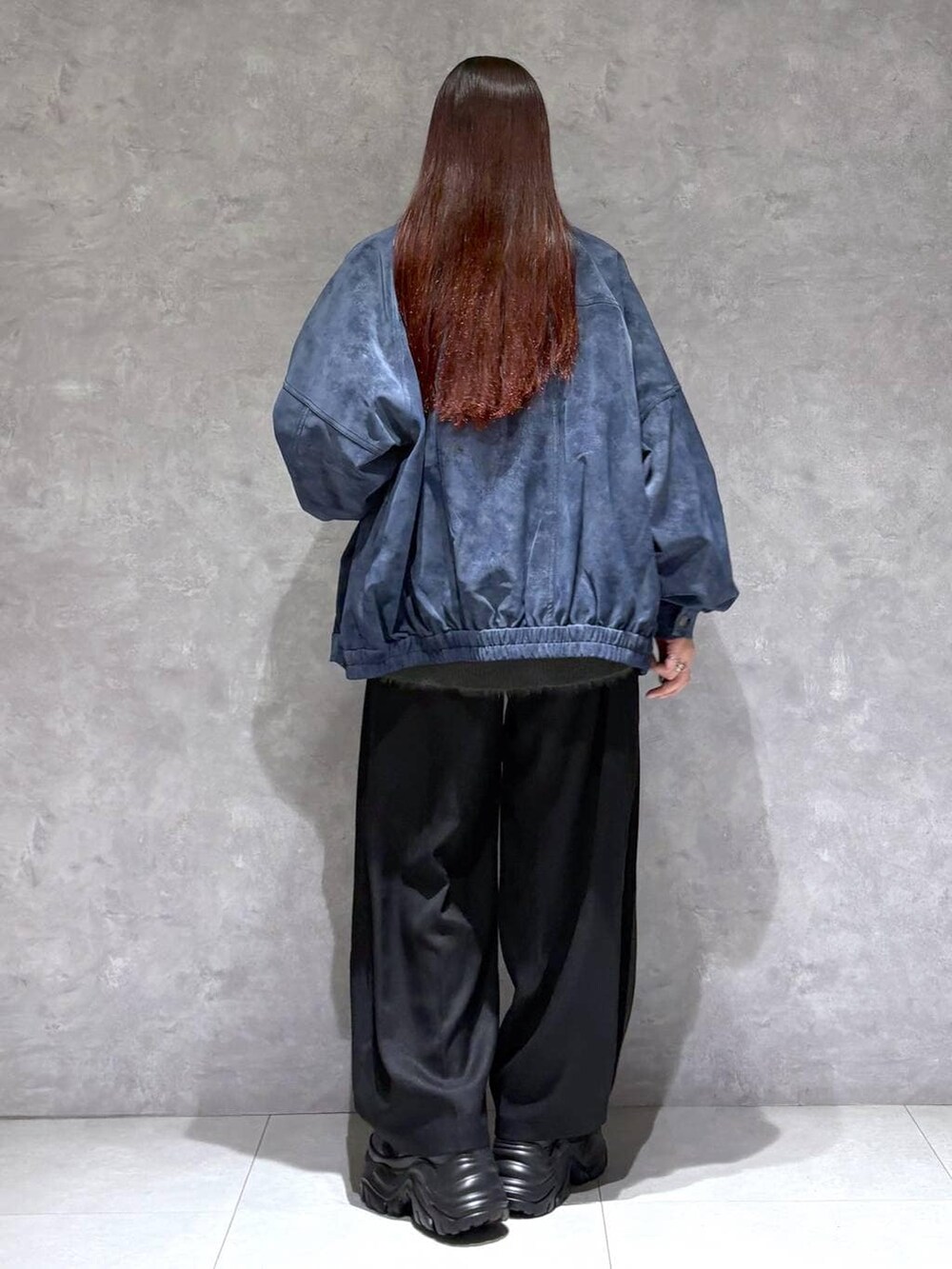 ブラック系のスニーカー、ブルー系のブルゾン、グレー系のニット/セーターを着用したレディースの秋コーディネートの5枚目の写真