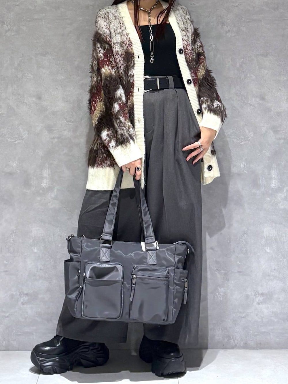 ブラック系のブーツ、グレー系のボストンバッグ、ホワイト系のカーディガン/ボレロを着用したレディースの秋コーディネートの3枚目の写真