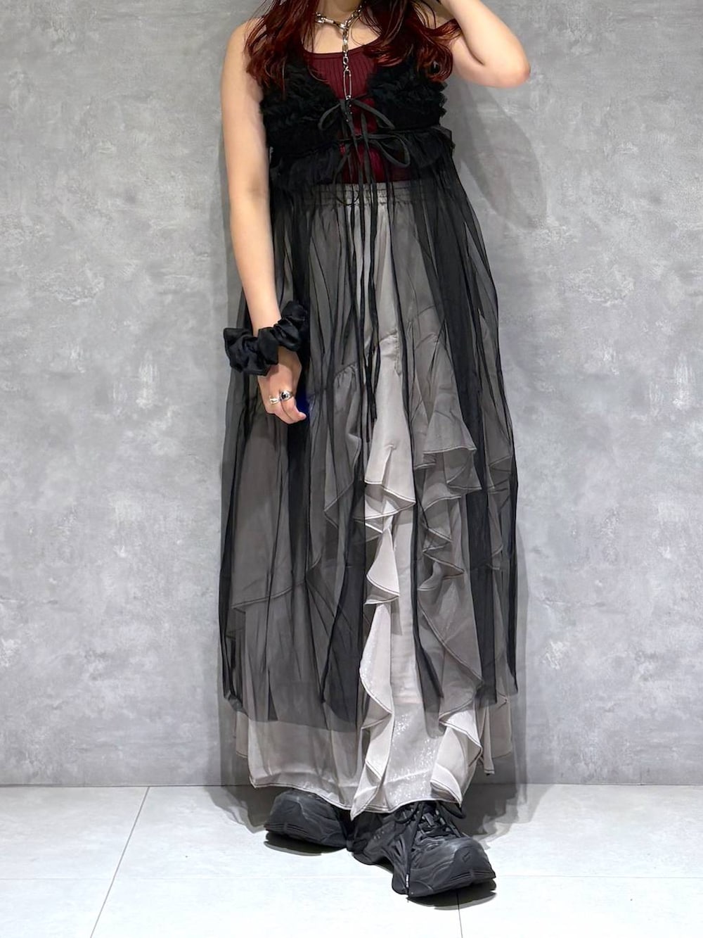 グレー系のスカート、レッド系のタンクトップ、ブラック系のワンピースを着用したレディースの夏コーディネートの3枚目の写真