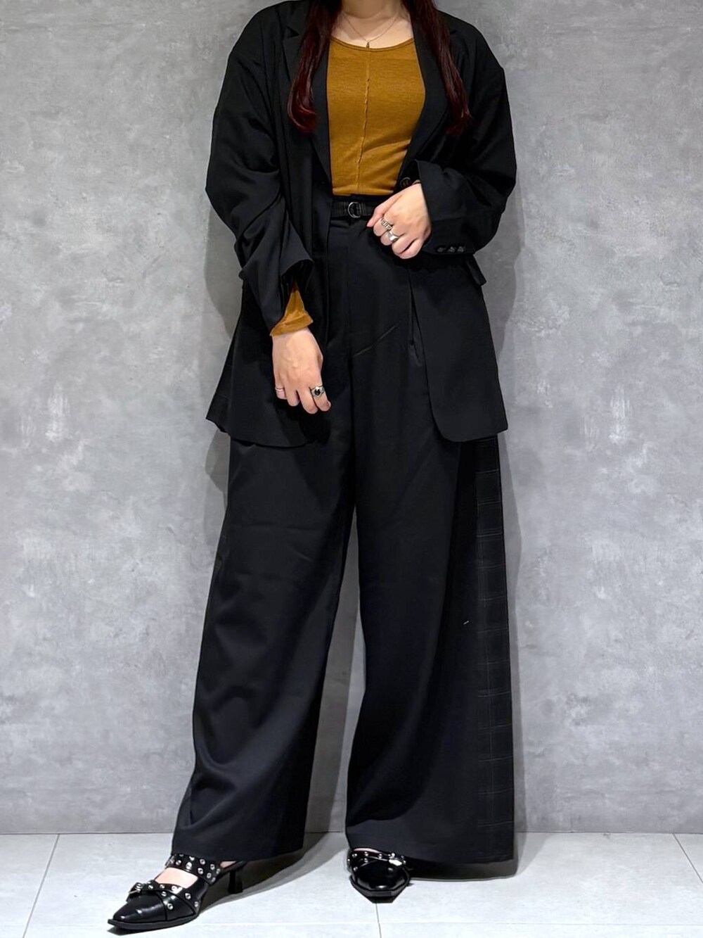 ブラック系のパンプス、ブラック系のテーラードジャケット、グレー系のスラックスを着用したレディースの秋コーディネートの7枚目の写真