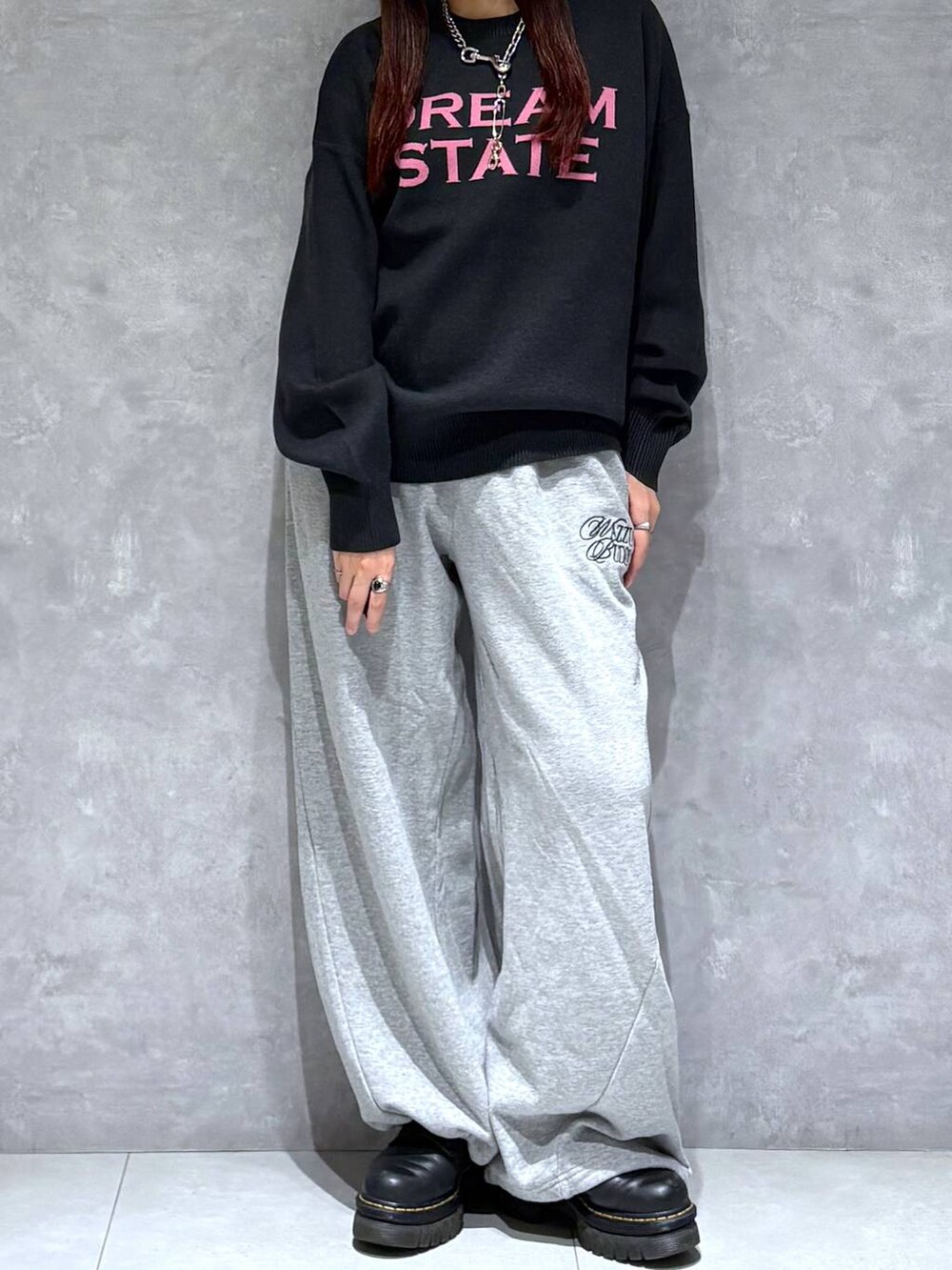 グレー系のスウェットパンツ、ブラック系のニット/セーターを着用したレディースの秋コーディネートの2枚目の写真