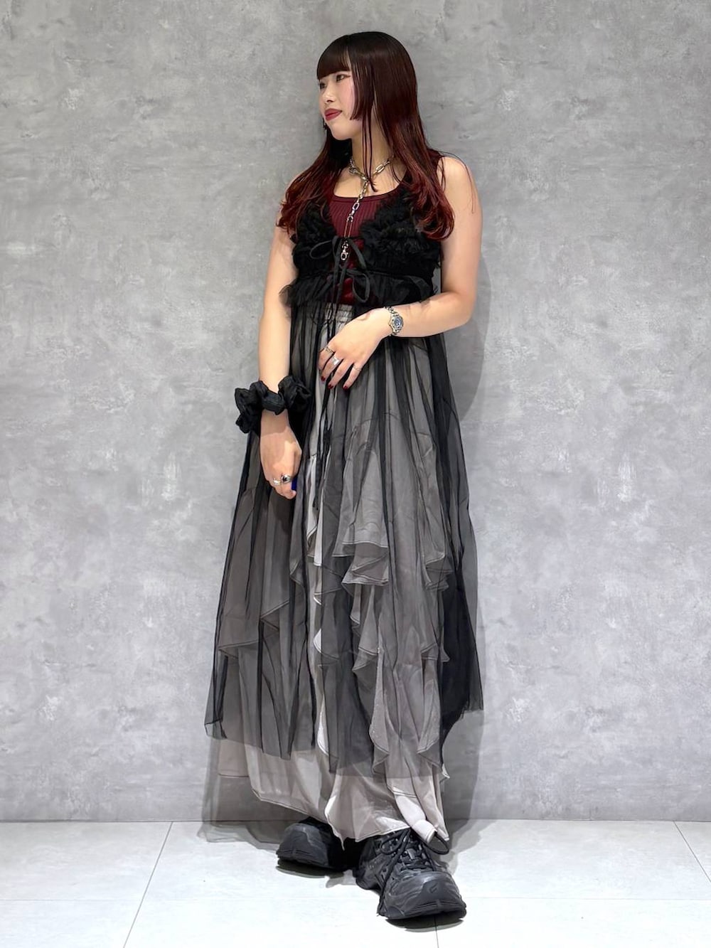 グレー系のスカート、レッド系のタンクトップ、ブラック系のワンピースを着用したレディースの夏コーディネートの8枚目の写真