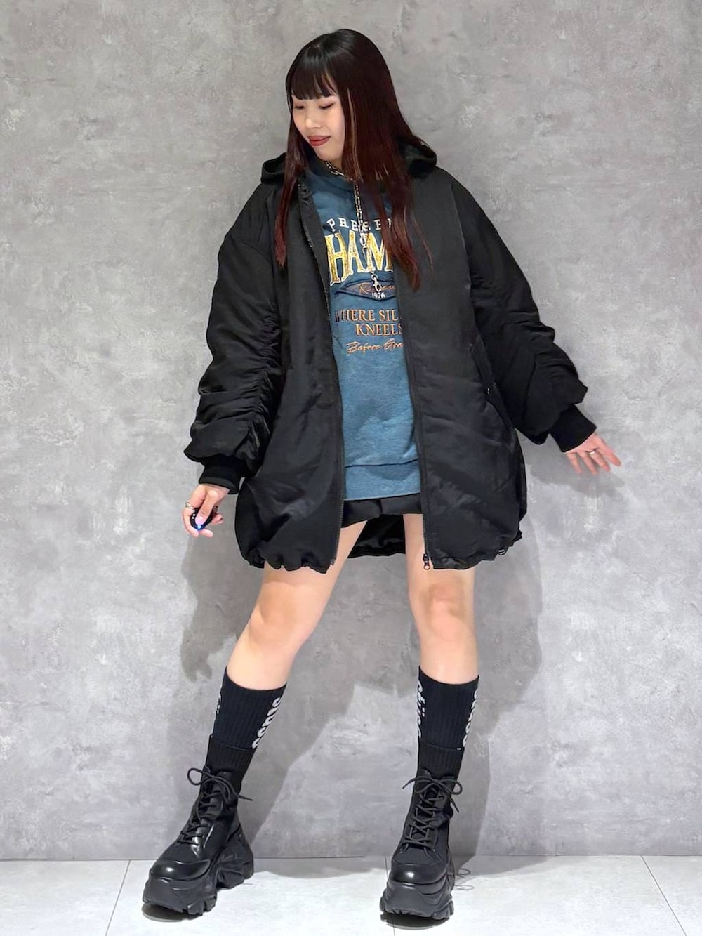 ブラック系のブーツ、グリーン系のスウェット、ブラック系のブルゾンを着用したレディースの冬コーディネートの2枚目の写真