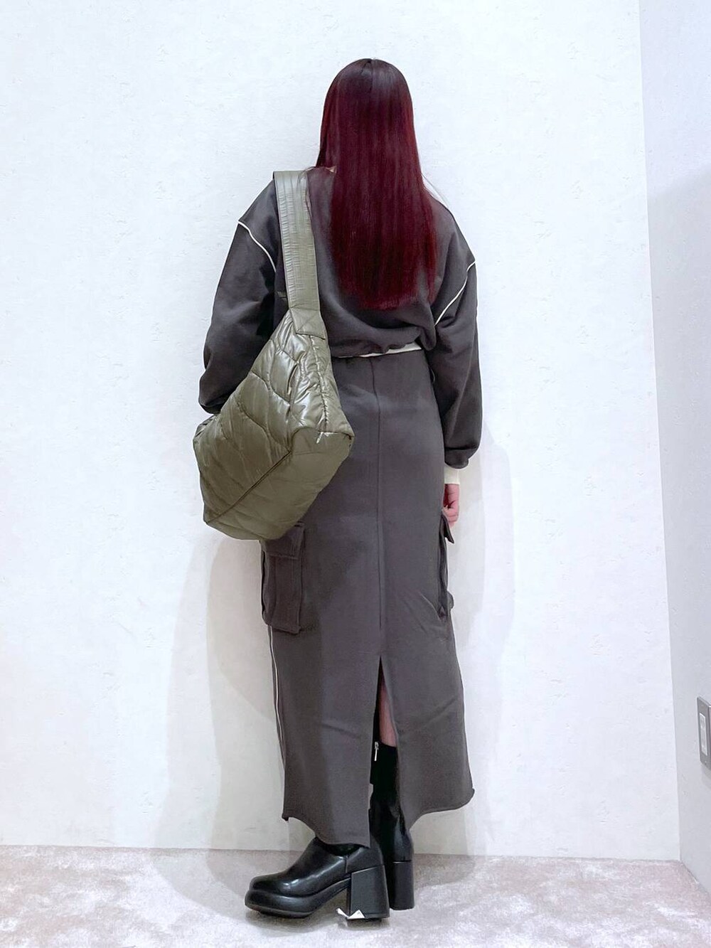 グレー系のスウェット、グレー系のスカート、ブラック系のブーツを着用したレディースの冬コーディネートの6枚目の写真