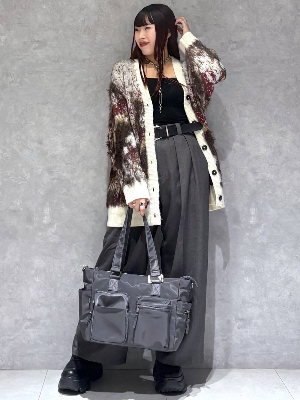 ブラック系のブーツ、グレー系のボストンバッグ、ホワイト系のカーディガン/ボレロを着用したレディースの秋コーディネートの4枚目の写真