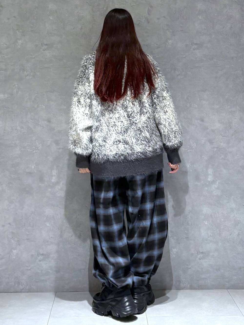 ブラック系のスニーカー、グレー系のニット/セーター、ブラック系のスラックスを着用したレディースの秋コーディネートの5枚目の写真