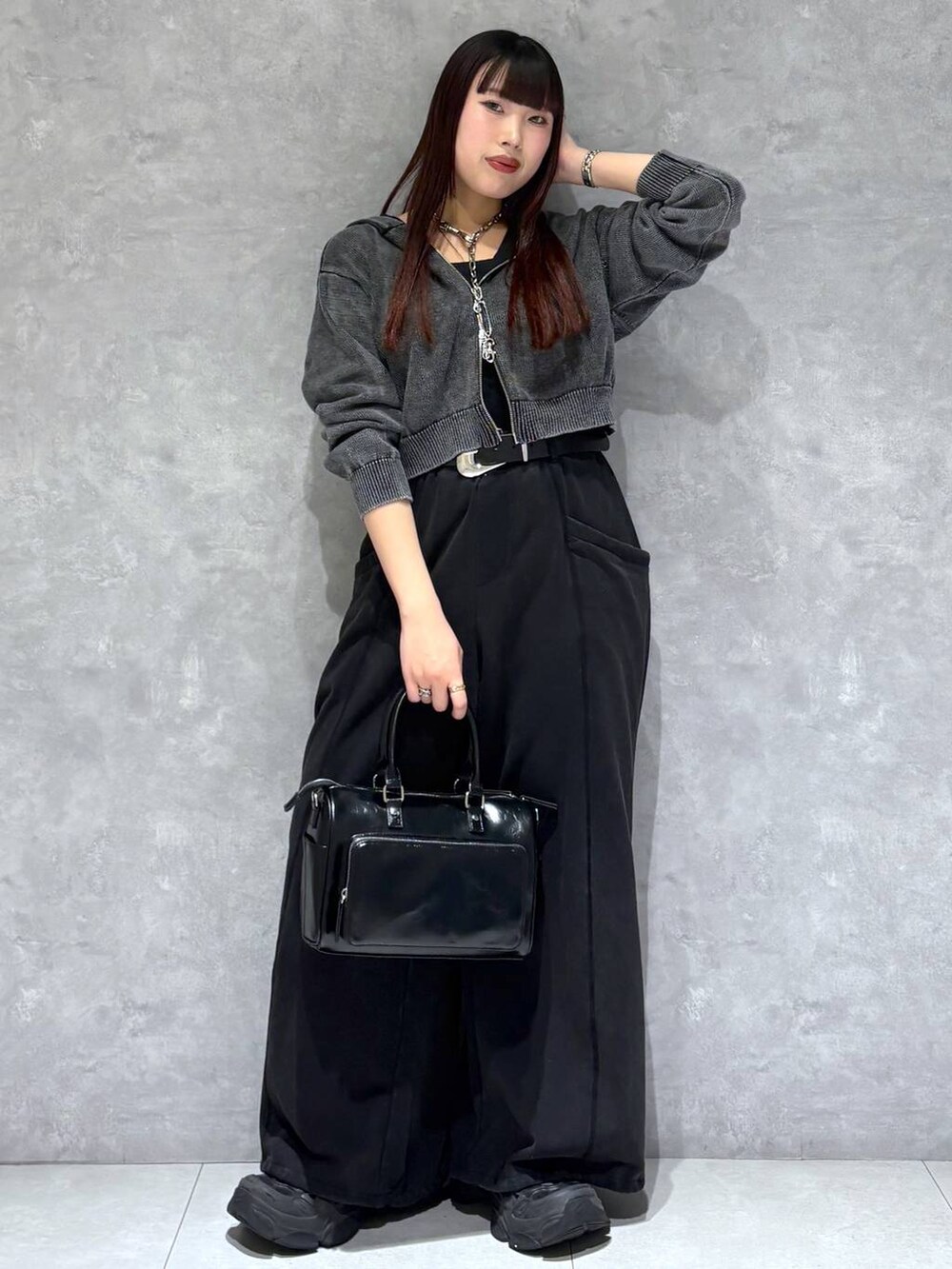 ブラック系のスウェットパンツ、ブラック系のショルダーバッグ、グレー系のパーカーを着用したレディースの冬コーディネートの8枚目の写真