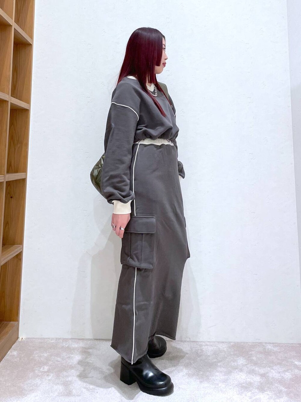 グレー系のスウェット、グレー系のスカート、ブラック系のブーツを着用したレディースの冬コーディネートの7枚目の写真