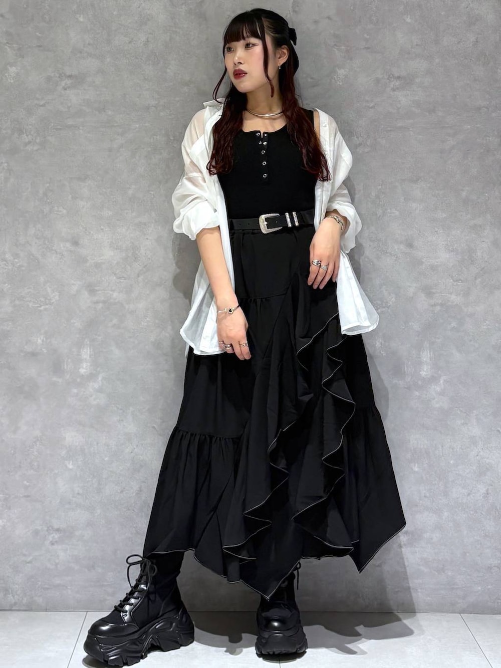 ブラック系のブーツ、ブラック系のスカート、ホワイト系のシャツ/ブラウスを着用したレディースの春コーディネートの6枚目の写真