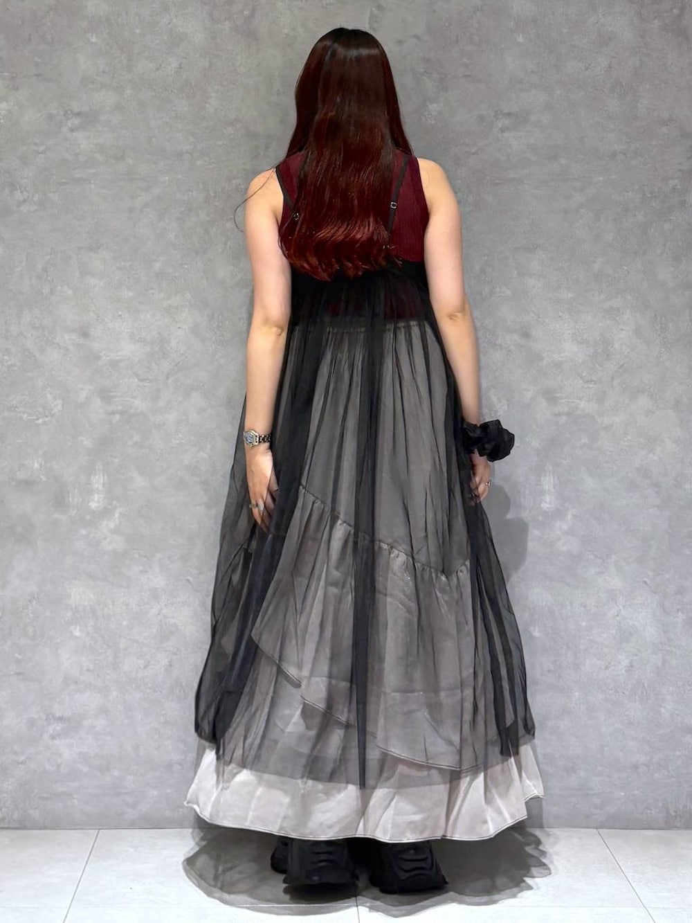 グレー系のスカート、レッド系のタンクトップ、ブラック系のワンピースを着用したレディースの夏コーディネートの5枚目の写真