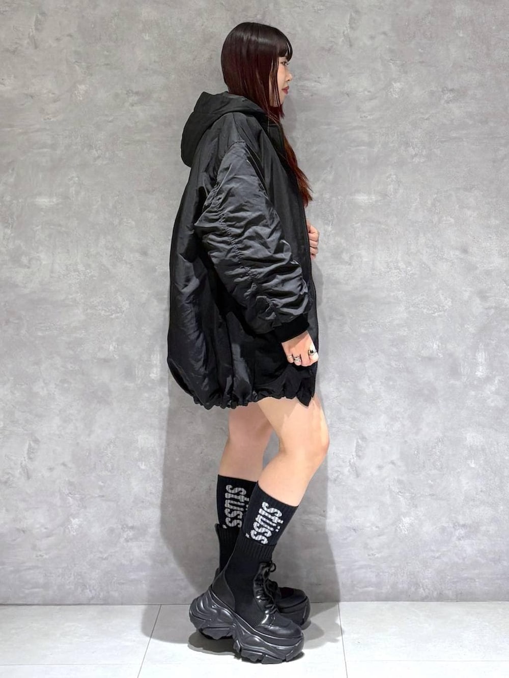 ブラック系のブーツ、グリーン系のスウェット、ブラック系のブルゾンを着用したレディースの冬コーディネートの6枚目の写真