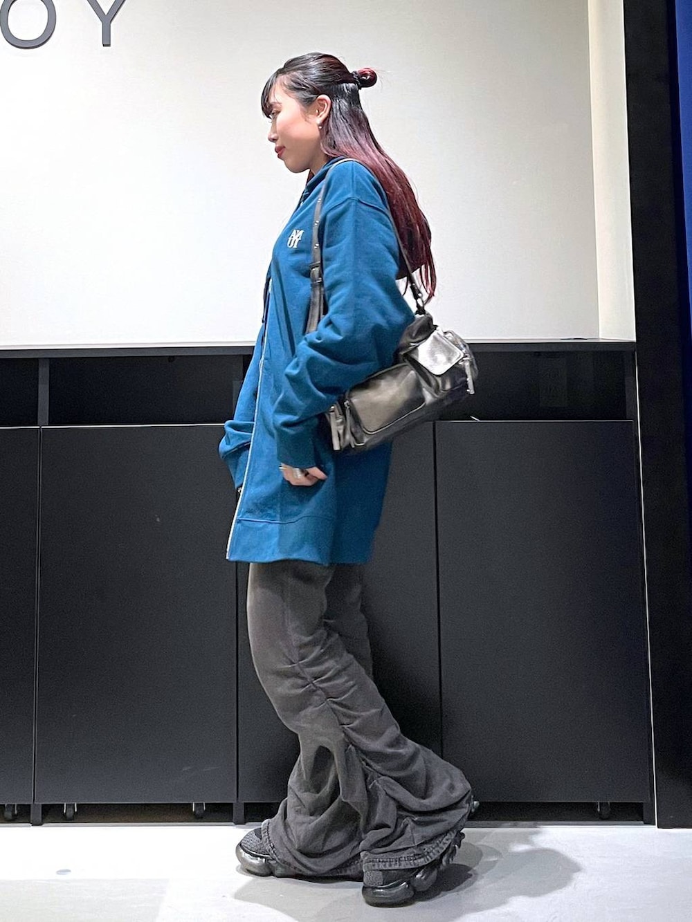 ブラック系のデニムパンツ、その他のショルダーバッグ、ブルー系のパーカーを着用したレディースの秋コーディネートの3枚目の写真