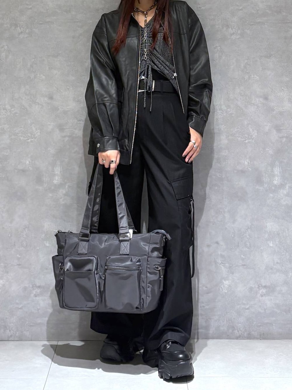 ブラック系のブーツ、グレー系のボストンバッグ、ブラック系のブルゾンを着用したレディースの秋コーディネートの8枚目の写真
