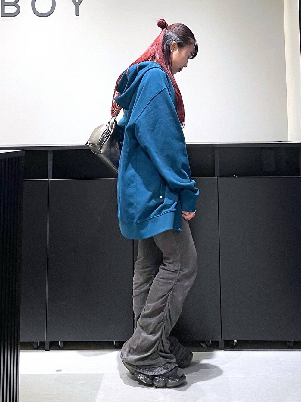 ブラック系のデニムパンツ、その他のショルダーバッグ、ブルー系のパーカーを着用したレディースの秋コーディネートの5枚目の写真