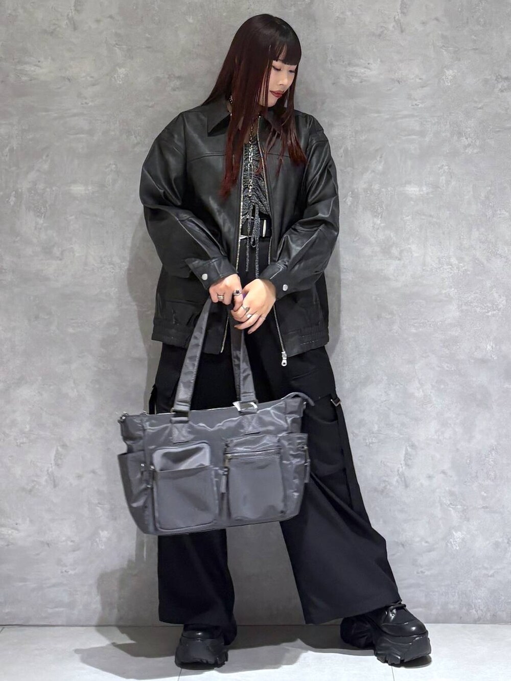 ブラック系のブーツ、グレー系のボストンバッグ、ブラック系のブルゾンを着用したレディースの秋コーディネートの7枚目の写真