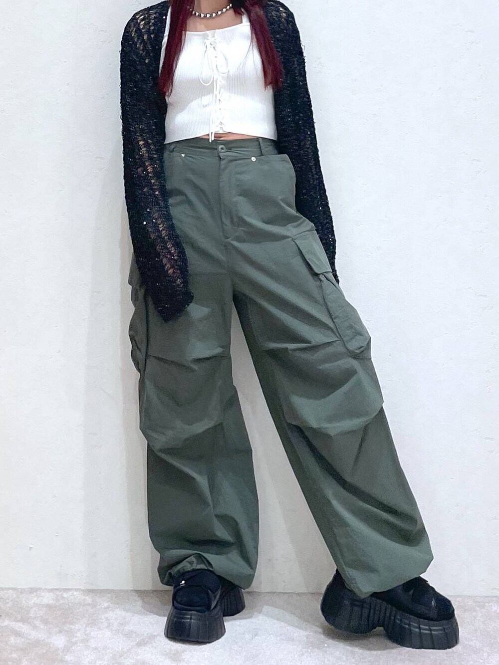 ブラック系のスニーカー、グリーン系のカーゴパンツ、ホワイト系のタンクトップを着用したレディースの春コーディネートの7枚目の写真