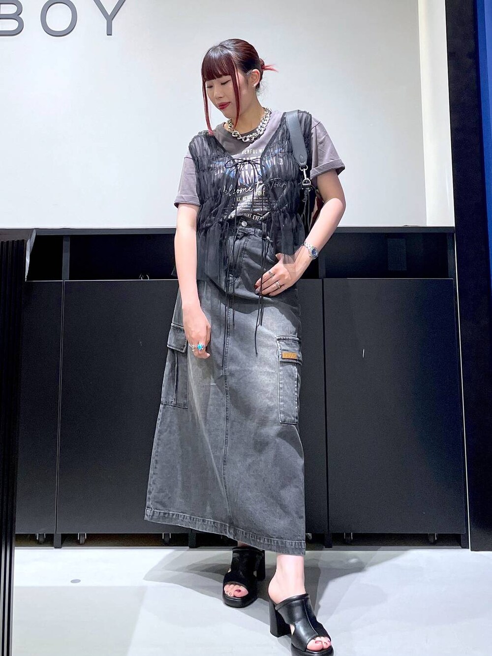 ブラック系のサンダル、ブラック系のデニムスカート、ブラック系のショルダーバッグを着用したレディースの夏コーディネートの3枚目の写真