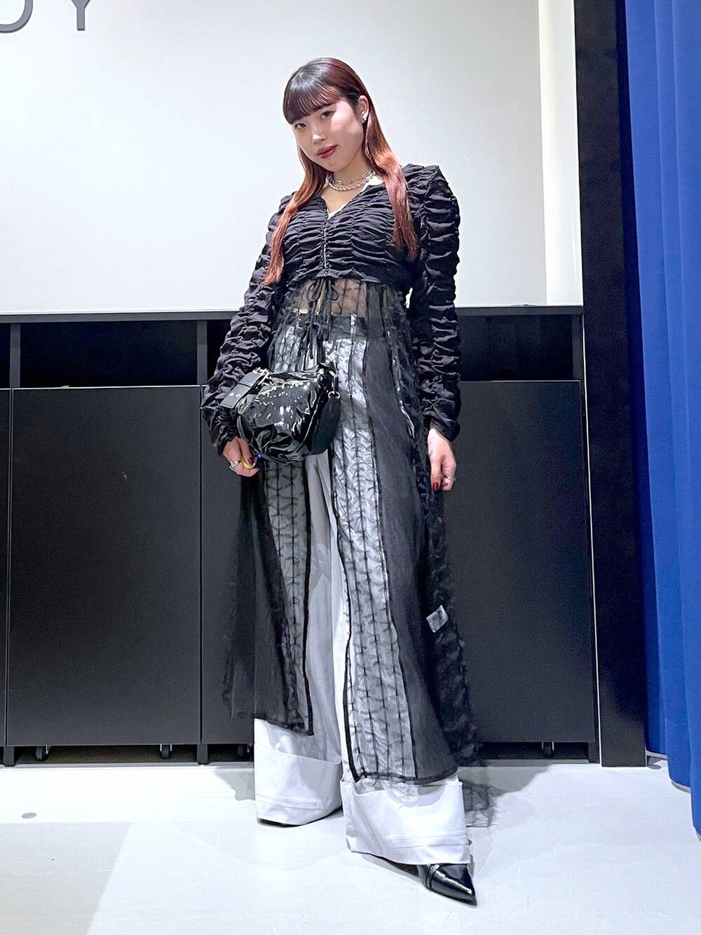 ブラック系のパンプス、ブラック系のショルダーバッグ、ブラック系のワンピースを着用したレディースの夏コーディネートの4枚目の写真