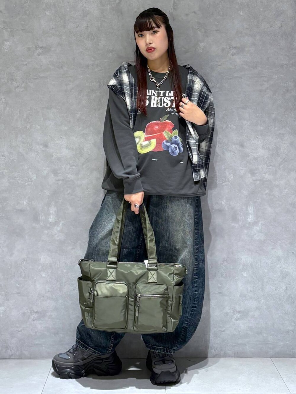 ブラック系のスニーカー、グリーン系のボストンバッグ、ブラック系のスウェットを着用したレディースの秋コーディネートの8枚目の写真