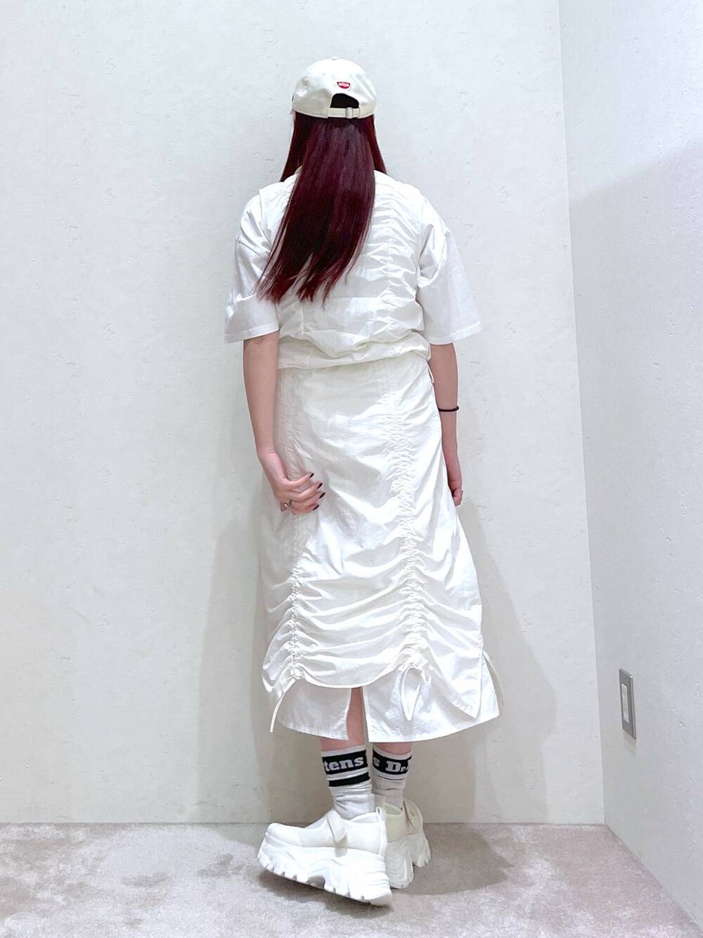 ホワイト系のベスト、ホワイト系のスカート、ホワイト系のTシャツ/カットソーを着用したレディースの春コーディネートの7枚目の写真