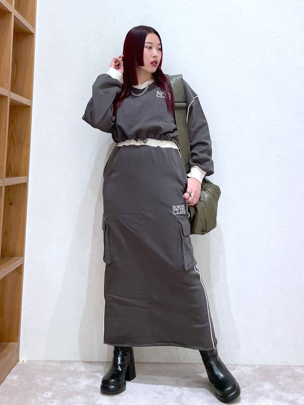 グレー系のスウェット、グレー系のスカート、ブラック系のブーツを着用したレディースの冬コーディネートの4枚目の写真