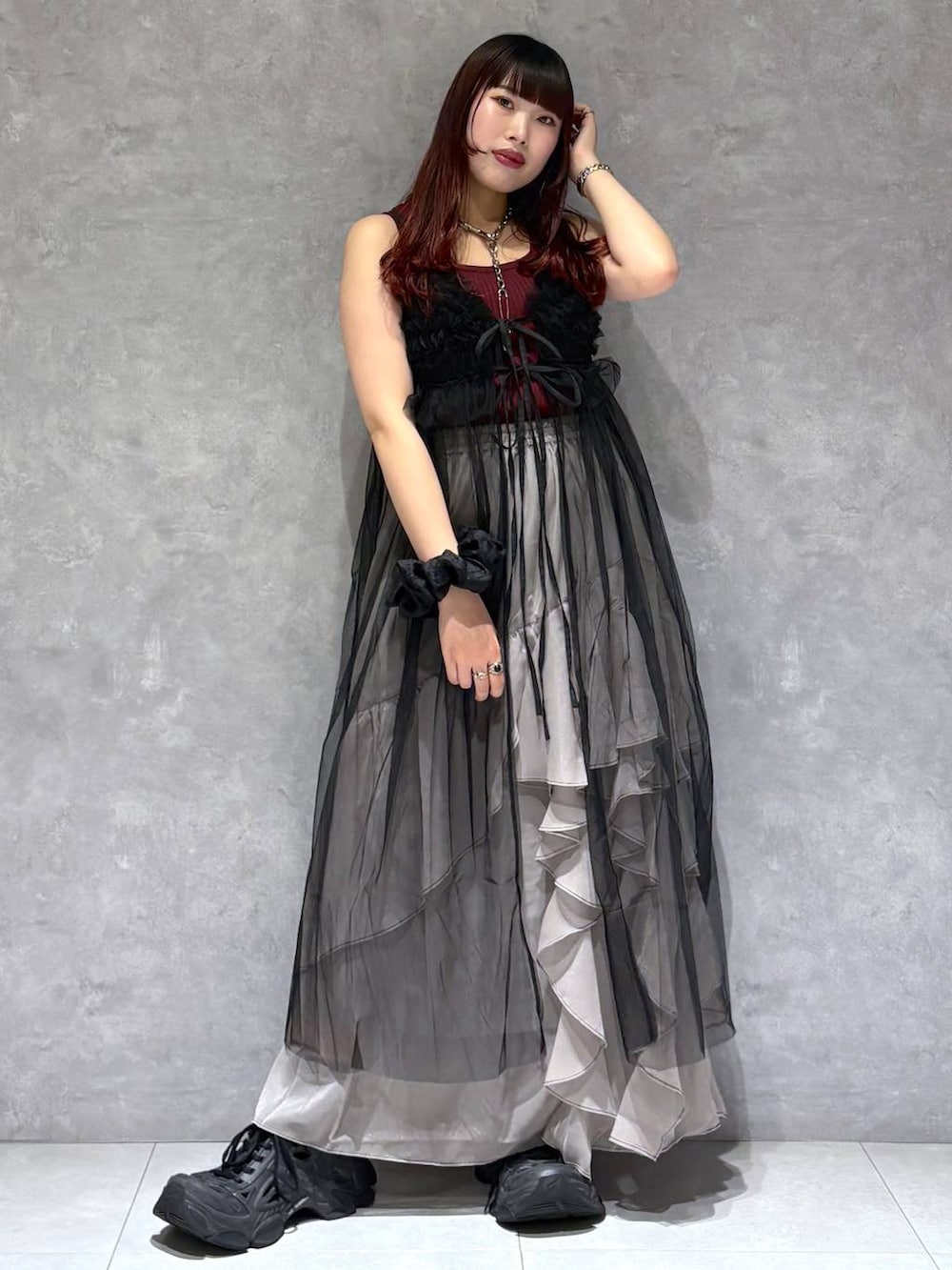 グレー系のスカート、レッド系のタンクトップ、ブラック系のワンピースを着用したレディースの夏コーディネートの2枚目の写真